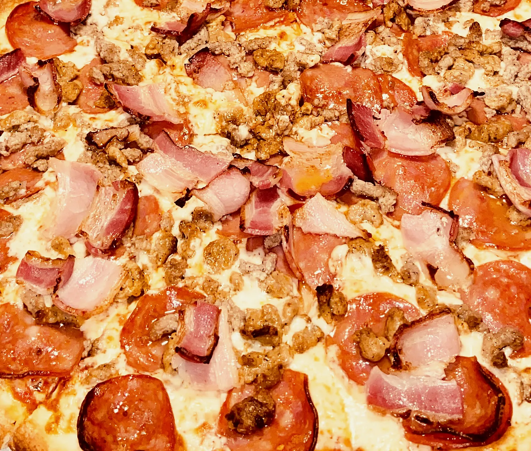 Close-up of pepperoni, bacon and sausage